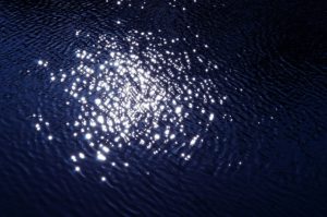 Photo of the atmospheric phenomenon sun glitter. Photo shows the surface of a body of water reflecting sun, like glitter.