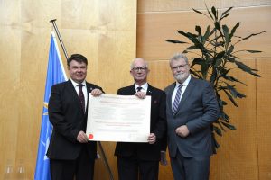 Three men including Gordon McBean, pictured in the centre, receiving the IMO prize.