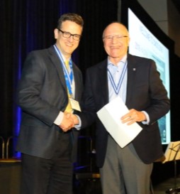 Paul Kushner and Wayne Richarson shaking hands at the 2018 Conress in Halifax. Photo for Paul's article on stewardship
