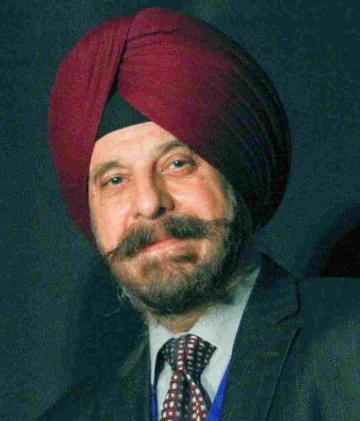 Photo shows a bearded Harinder Ahluwalia, president of IFMS, of middle eastern descent, smiling and wearing a burgundy turban. 