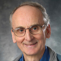 Headshot of a smiling Terry Gillespie. Clean-shaven man with glasses and thinning gray hair.