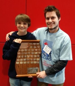 CMOS Awards photo shows a young boy standing with Gregory Steeves, holding an award.