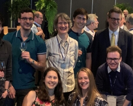 Kimberly Strong, CMOS President, pictured standing with a group of about 6 students at the IUGG General Assembly CMOS Banquet. All smiling and relaxed.