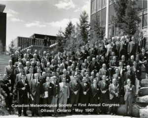 black and white photo of dozens of men in suits in front of a building at CMOS's first Congress in 1967.
