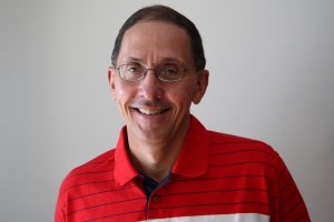 Smiling Caucasian man with glasses and red striped shirt