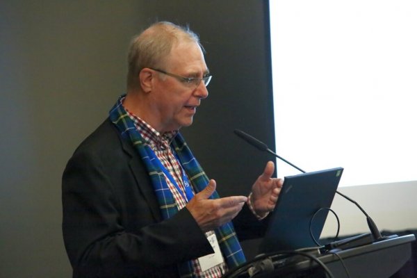 Man with animated hands giving a speach at a podium